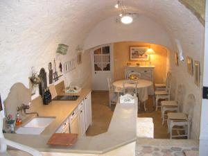 eine Küche mit einem Waschbecken und einem Tisch in einem Zimmer in der Unterkunft Moulin de maître Cornille in Castillon-du-Gard