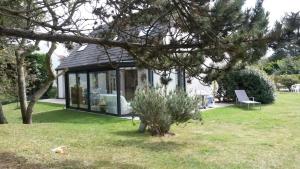 a black and white house with a tree at Aux doux Becots - Bed & Breakfast in Hardelot-Plage