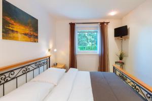 a bedroom with a large white bed and a window at Apartments Patricia in Bled