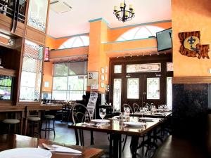a dining room with tables and chairs in a restaurant at Bourbon St. Boutique Hotel in Bangkok