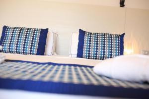 a bed with blue and white pillows in a room at Bajaloglia Resort in Castelsardo