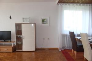 sala de estar con mesa, TV y armario en Apartment 31 en Kassel