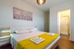 マトゥリにあるApartments Villa Sonjaのタオルが敷かれた大きなベッドのある寝室