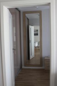 a hallway with a mirror and a room with a table at Apartament z ogrodkiem in Pogorzelica