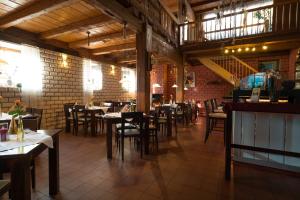 a restaurant with tables and chairs and a brick wall at Wellnesshotel & Restaurant Hexenschopf in Löffingen