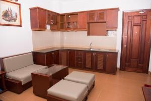 a kitchen with wooden cabinets and a sink and a table at Ocean Star Hotel in Vung Tau