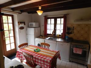 una cocina con mesa y mantel. en Le Moulin L'Eveque en Campeaux