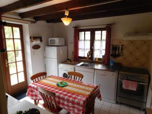 - une cuisine avec une table et une nappe dans l'établissement Le Moulin L'Eveque, à Campeaux
