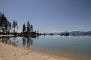 um corpo de água com árvores e uma praia em Avalon Lodge South Lake Tahoe em South Lake Tahoe