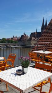 a table with flowers on top of a balcony at SORAT Insel-Hotel Regensburg in Regensburg