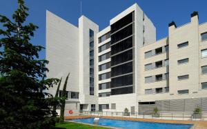 - un grand bâtiment blanc avec une piscine en face dans l'établissement Vincci Frontaura, à Valladolid