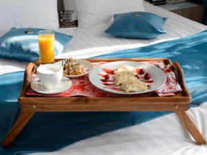 a tray of food and a cup of coffee on a bed at Kupechesky Dvor in Irkutsk