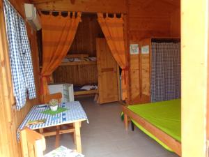 una habitación con una mesa y una cama en una cabaña en Bungalow Janet, en Cassibile