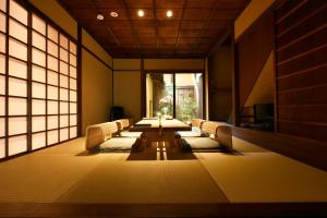 Großes Zimmer mit einem langen Tisch und Stühlen in der Unterkunft Kuraya Kiyomizu Gojo in Kyoto