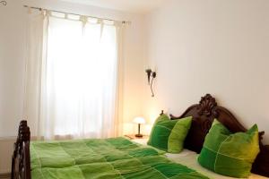 una camera da letto con letto con lenzuola verdi e finestra di Ferienwohnung Anna Frieda a Loxstedt