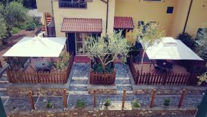 una casa con dos sombrillas blancas en las escaleras en Salvia e Rosmarino - Affittacamere in Liguria, en Villanova dʼAlbenga