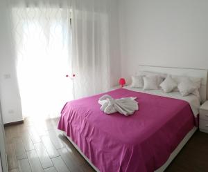 - une chambre avec un lit rose et une serviette dans l'établissement Da Lucia, à Rome