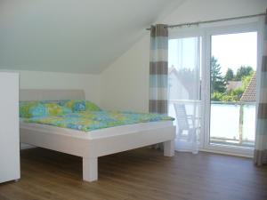 ein Schlafzimmer mit einem Bett und einem großen Fenster in der Unterkunft Ferienwohnung Rheinaue in Köln