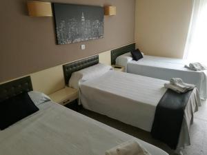 Giường trong phòng chung tại Hostal Isla Playa