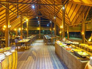 un comedor con mesas, sillas y luces en Siddhalepa Ayurveda Resort - All Meals, Ayurveda Treatment and Yoga, en Wadduwa