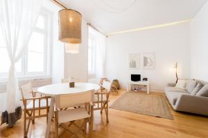 リスボンにあるFLH Baixa Modern Apartmentの白いリビングルーム(テーブル、椅子付)