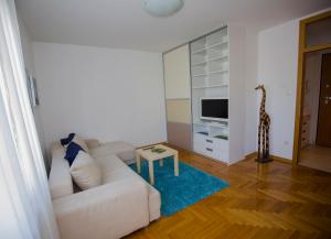 sala de estar con sofá blanco y TV en Apartment Luka, en Zagreb