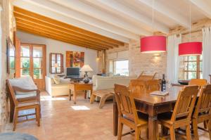 a living room with a table and chairs at Villa Es Molí­ Des Trenc in Campos