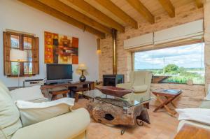a living room with a couch and chairs and a tv at Villa Es Molí­ Des Trenc in Campos