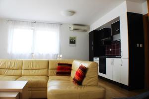 Bokun Apartments III في سيساك: غرفة معيشة مع أريكة ومطبخ