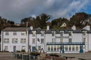 un edificio blanco con una bandera delante de él en Penhelig Arms en Aberdyfi