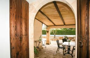 una puerta arqueada a un patio con mesa y sillas en Agroturisme Son Barceló Mas, en Campos