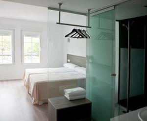 - une chambre avec un lit et un mur en verre dans l'établissement Hostal Central, à Fuente-Álamo