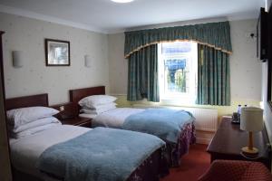a hotel room with two beds and a window at Clifton Bridge Guesthouse in York