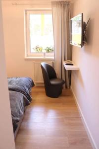 a bedroom with a chair and a window at Morski Relax in Gdynia