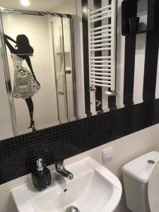 a bathroom with a sink and a picture of a woman in the mirror at Morski Relax in Gdynia