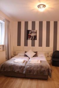 a bedroom with a bed with a striped wall at Morski Relax in Gdynia