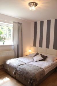 a bedroom with a large bed with a striped wall at Morski Relax in Gdynia