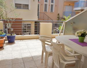 a patio with a table and chairs on a balcony at Ameris Studios & Apartments in Neos Marmaras