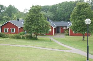 a row of red houses with a path in front at Allégården Kastlösa Vandrarhem in Kastlösa