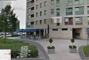 a building with a cafe in front of it at Apartament Dymińska in Warsaw