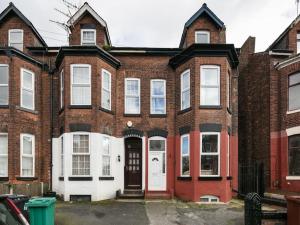 マンチェスターにあるChorlton Townhouseの白い扉のある古いレンガ造りの家