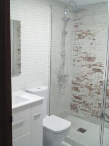 a white bathroom with a toilet and a shower at Apartamento Buendia in Buendía