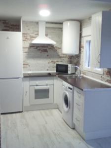 eine weiße Küche mit einer Spüle und einem Geschirrspüler in der Unterkunft Apartamento Buendia in Buendía