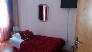 a bedroom with a bed with a red blanket at Alojamento Cesarini in Montijo