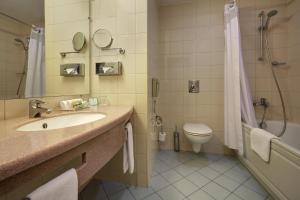
a bathroom with a toilet, sink, and shower at Holiday Inn Moscow Lesnaya, an IHG Hotel in Moscow
