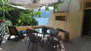 a table and chairs on a patio with a view of the water at Apartments Andrea in Baška