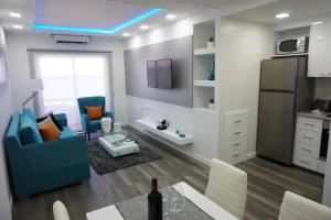 a living room with a blue couch and a kitchen at Lazuli Sea View Beachfront Ap 43 in Larnaka