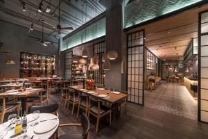 a restaurant with tables and chairs in a room at Downtown Al Bahar Apartments in Dubai