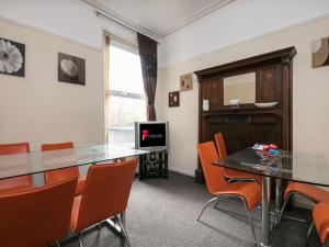 comedor con mesa y sillas naranjas en Chorlton Townhouse, en Mánchester