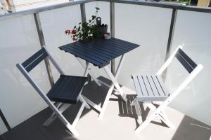 a table and chairs on a balcony with a potted plant at RGB studio in Lublin